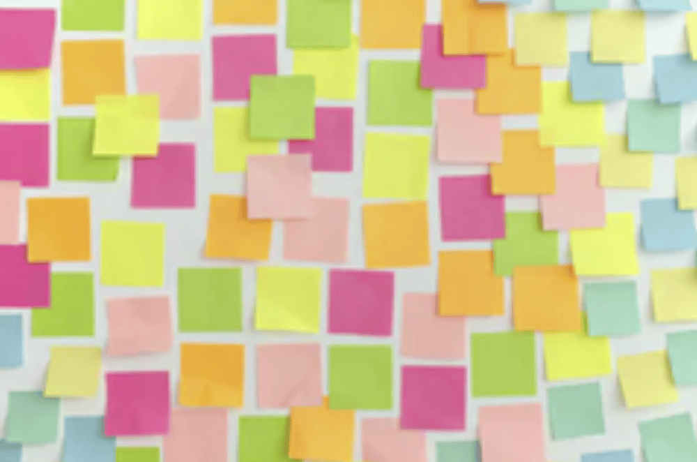 A multitude of unwritten sticky notes on a whiteboard.